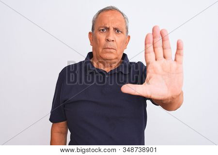 Senior grey-haired man wearing black casual standing over isolated white background doing stop sing with palm of the hand. Warning expression with negative and serious gesture on the face.