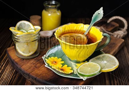 Tea Party, Bright Yellow Mug Of Tea, Tea With Lemon And Honey On A Wooden Board, A Mug Of Tea And Le