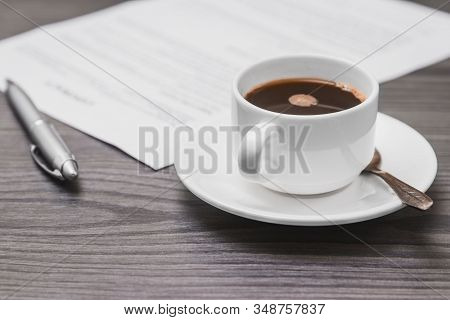 Contract Signing Concept, Close-up Cup Of Coffee, Silver Pen And Empty Paper Sheet Of Agreement Betw