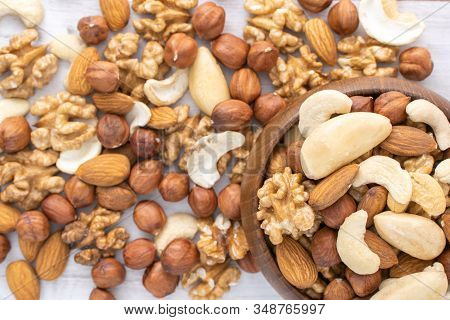 Different Nuts In Wooden Bowl On Wood Table