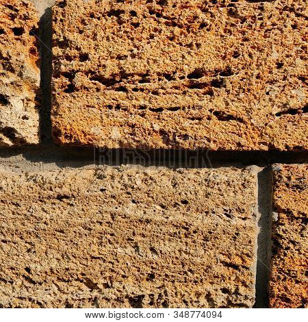 Brick Wall Of Yellow Shell Rock. Closeup Of Shellstone Texture. Background.