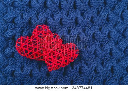 Two Beautiful Red Hearts On The Blue Knitted Background. St Valentines Concept With Copy Space.