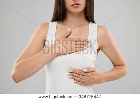 Clolse Up Of Incognito Caucasian Woman In White Shirt Posing Over Gray Isolated Background And Touch