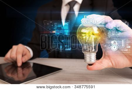 Businessman holding lightbulb with EMAIL SECURITY inscription, online security idea concept