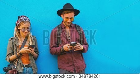 Friends Chatting In Their Own Smartphones - Boy And Girl Playing Games Online - Teenegers Standing B