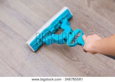 Young Girl Housekeeper Is Washng Wooden Floor With Mop With A Hand Wringer. Domestic Chores Concept