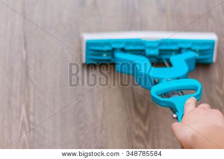 Young Girl Housekeeper Is Washng Wooden Floor With Mop With A Hand Wringer. Domestic Chores Concept