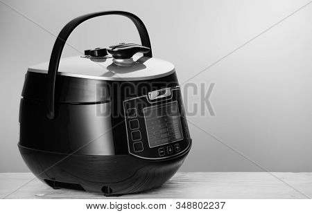 Black Modern Multicooker, On A White Wooden Table. With Space For Text.