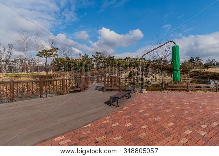 Walkway In City Park Next To Pond In City Public Park On Beautiful Partly Cloudy Winter Day.