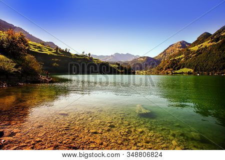 Lake Lungern Switzerland - Famous Fishing Lake In Switzerland. Stones And Reflection In Water