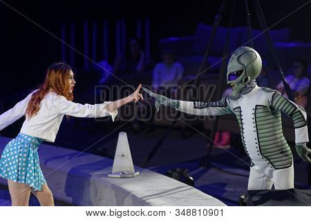 ST. PETERSBURG, RUSSIA - DECEMBER 27, 2019: Circus actors showing the contact with an extraterranean on the circus arena during the premiere of the show OFU. Landing in Saint-Petersburg