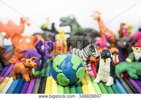 Animals Made From Play Clay With Earth Planet In Middle.