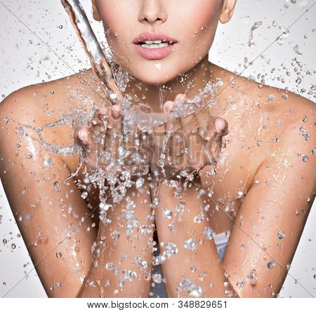 ?aucasian woman washing her clean face with water  