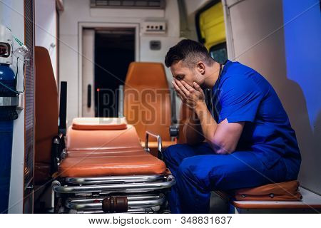 Tired Corpsman In Medical Uniform Sits Inside The Ambulance