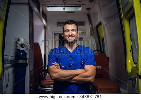 Smiling Corpsman In Medical Uniform Stands In The Ambulance Car