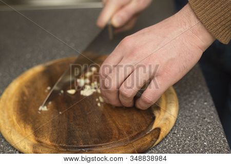 Man Cutting Garlic With A Knife. Vegetable Prepring In The Kitchen Bord. Healhy Chopping Ingreient.