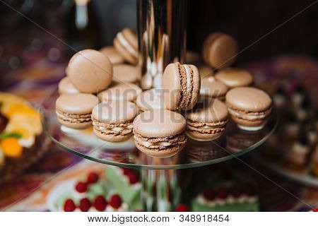 Chocolate Macaroons Lie On A Glass Slide For Desserts. Candy Bar.