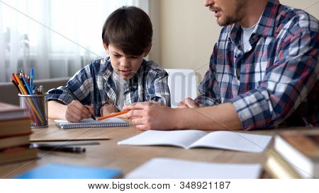 Dad Sitting At The Table And Making His Capricious Son To Do Homework, Education