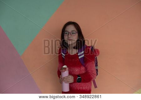 Girl With Cup. Schoolgirl Girl In Glasses Drinks Water From A Thermomug.a Schoolgirl Drinks Tea, Jui