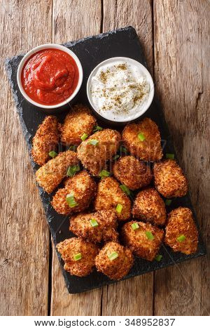Deep-fried Coconut Breaded Chicken With Two Sauces Close-up On A Slate Board. Vertical Top View