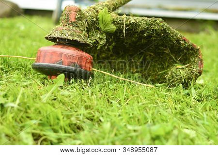 Trimmer Close Up Mow The Grass With A Lawnmower. Gardening With A Brush Cutter Close-up. Lawn Care W