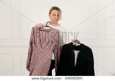 A Woman Has A Difficult Choice, Not Knowing What To Wear. Evening Dress Or Business Suit. Nothing To