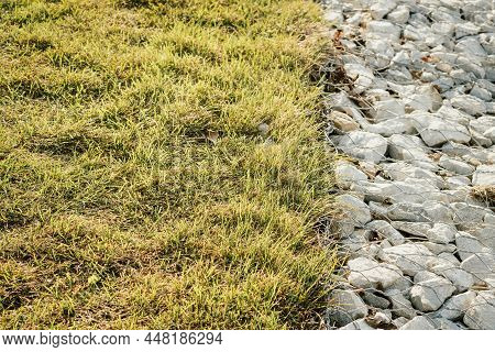 Granite Stones Behind A Metal Grate For Strengthening The Slope. Stones Behind The Wire. Grey Textur