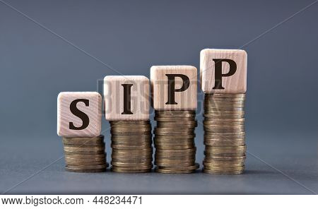 Sipp (self Invested Personal Pension) - Acronym On Wooden Cubes On Coins On A Gray Background. Busin