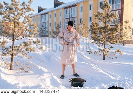 Portrait Of Willed Young Man Taking Off Robe, Getting Ready For Hardening Procedure Outside, Holding