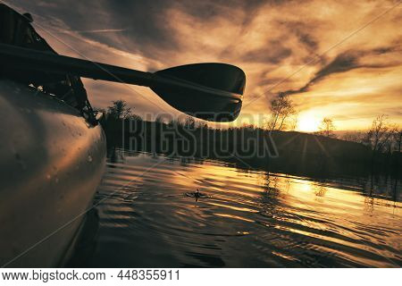 Kayaking On A Lake In The Sunset With Closeup On The Paddle