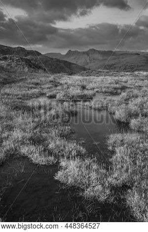 Black And White Epic Landscape Image Of Stunning Autumn Sunset Light Across Langdale Pikes Looking F