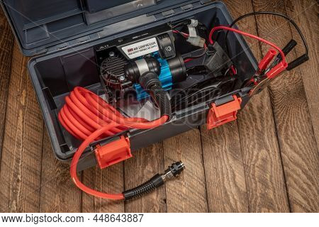 Fort Collins, CO, USA - February, 4, 2022: ARB 12V high performance portable air compressor on a rustic wooden deck.