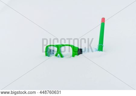 Snow Fun. Green Diving Goggles,snorkel On White Snow.scuba Snorkeling Green Diving Set Flat Lay On T