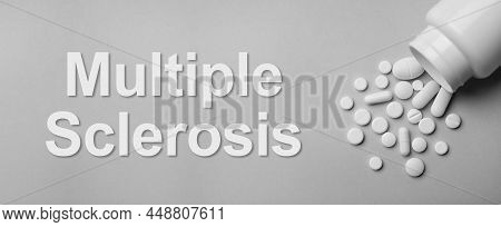 Multiple Sclerosis Treatment. Bottle With Different Pills On Grey Background, Flat Lay
