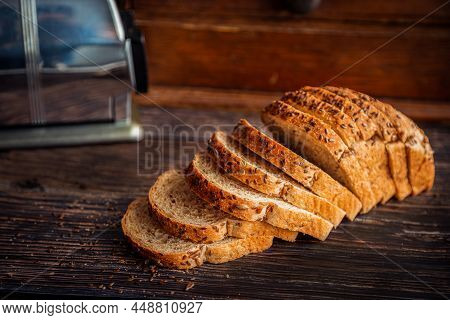 Freshly Baked Whole Wheat Flax And Sunflower Seed Bread Sliced On Rustic Wooden Table With Bread Box