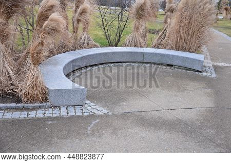Japanese Tall Dry Grasses For The Winter Tied In Sheaves. In The Arch Of The Flowerbed Surround The 
