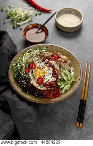 Traditional Korean Dish Bibimbap. Bowl With Rice, Shiitake Mushrooms, Chicken, Cucumber And Microgre