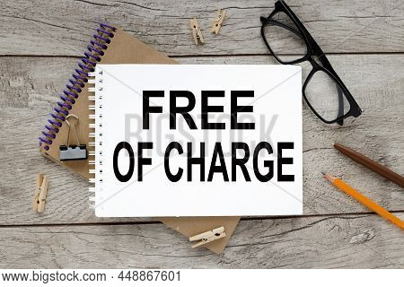 Foc - Free Of Charge. Open Notepadon Notepad With Text On Rustic Background. Business Concept