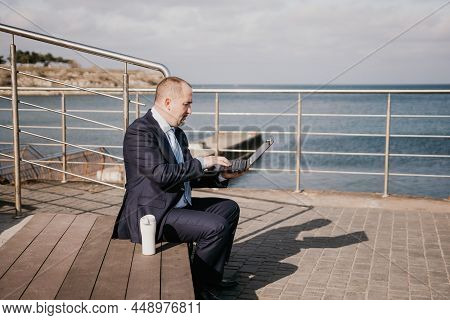 Confident Middle Age Businessman Working Remotely Online, Typing On A Laptop Keyboard While Sitting 
