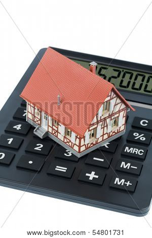 residential building on a calculator, symbolic photo for home purchase, costs and savings
