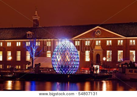 AMSTERDAM, NETHERLANDS - DECEMBER 07 2012: Illuminated Hermitage museum with in front a luminous egg, an element of the first edition of the Amsterdam Light Festival on DECEMBER 07, 2012 in Amsterdam.
