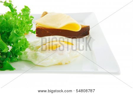 green lettuce salad and fried eggs on white