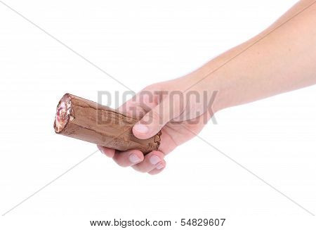 Hand holds roll of chocolate ice cream.