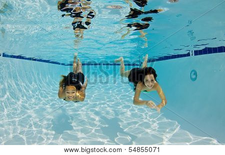 Smiling Girls Swimming Underwater