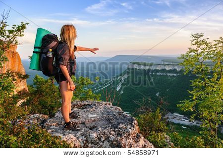 Young hiking woman in the rays of sunset, standing at the top of Tope Kermen, Crimea, Ukraine
