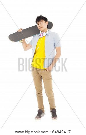 Young Man Standing And Holding A Skateboard