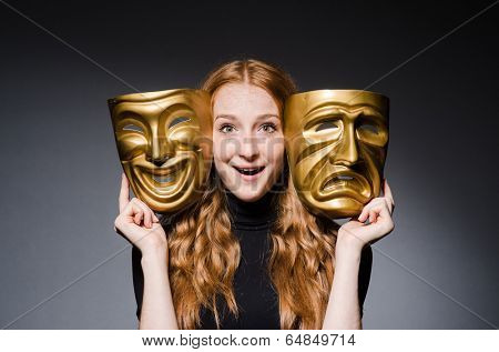 Redhead woman iwith masks in hypocrisy consept against grey background