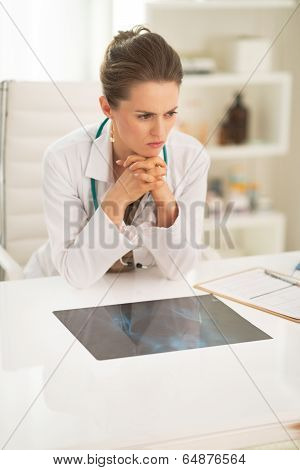 Thoughtful Medical Doctor Woman With Fluorography In Office