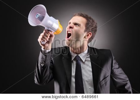 Empresario enojado anunciando por altavoz