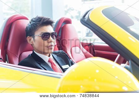 Asian man testing new sports car